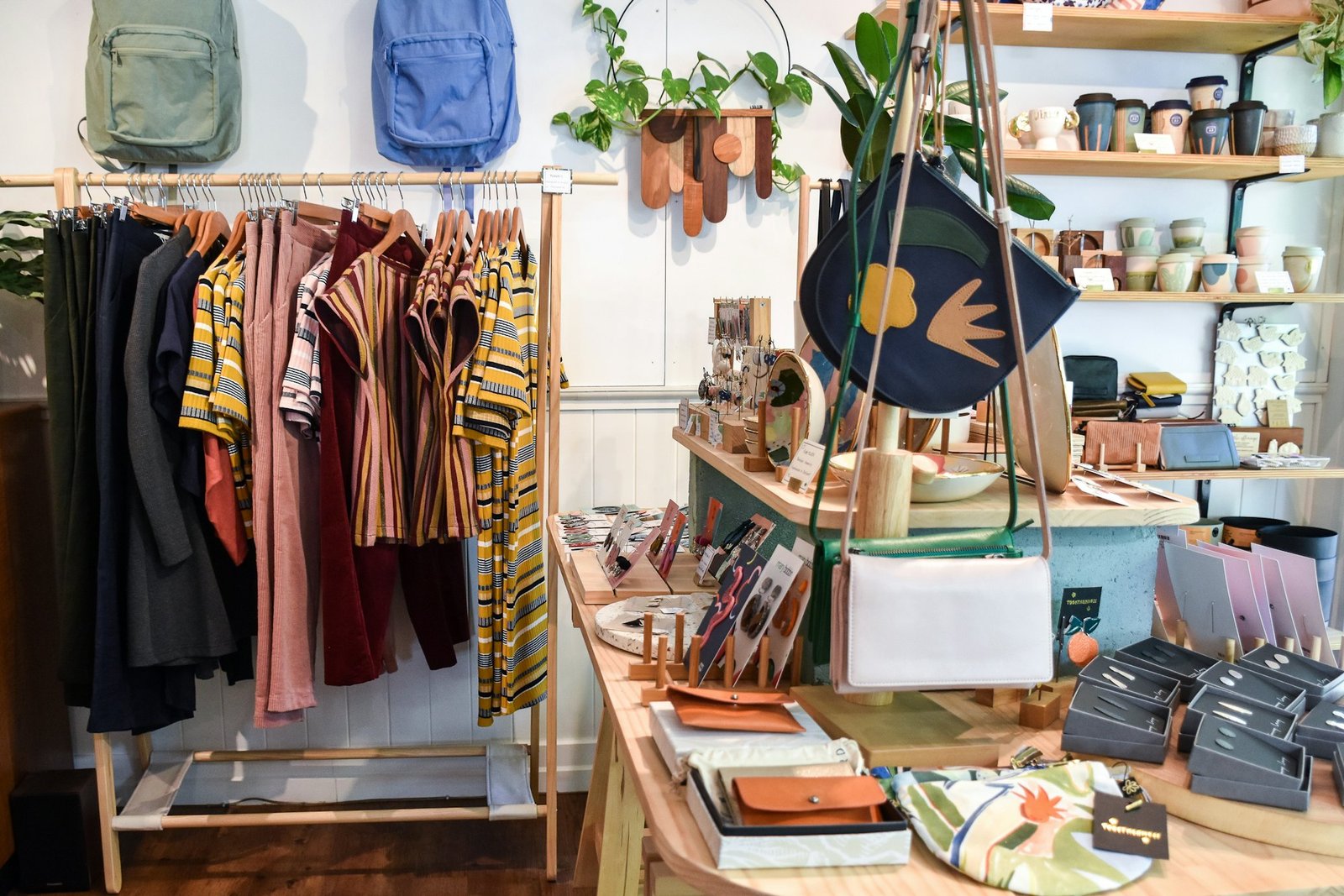 Liebevoll eingerichtete Boutique mit Kleiderständer, Holztisch und Accessoires